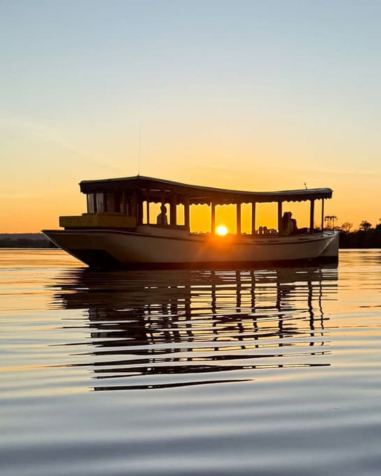 Zambezi river cruise at sunset with guests on the water